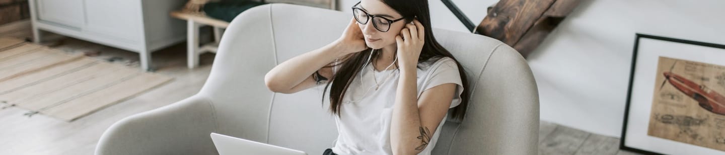 woman videochatting using a laptop and earphones